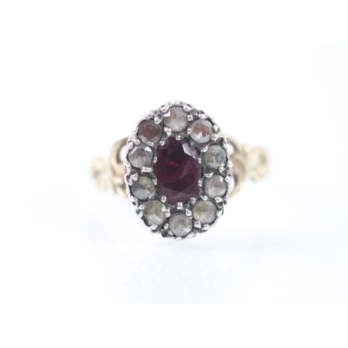 398 - An early 19th century untested ruby and diamond cluster ring, the central oval cut ruby within a sur... 