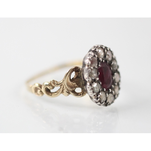 398 - An early 19th century untested ruby and diamond cluster ring, the central oval cut ruby within a sur... 