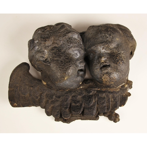 562 - A carved pine fragment modelled as two cherubs, heavily patinated, 22cm wide (at fault)