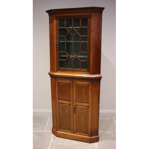 1212 - An Edwardian walnut freestanding corner display cabinet, the moulded cornice over an astragal glazed... 