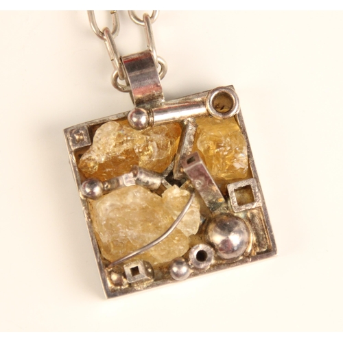 386 - A ‘Wiggers’ citrine pendant, the square silver coloured pendant with rough cut pieces of citrine wit... 