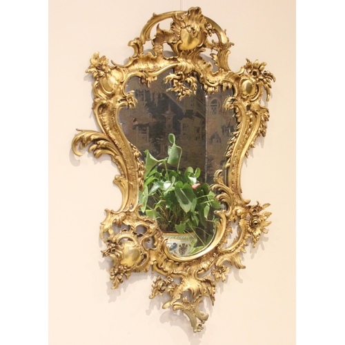 1067 - A Louis XVI style rococo gilt metal wall mirror, 20th century, the shield shaped mirrored plate with... 