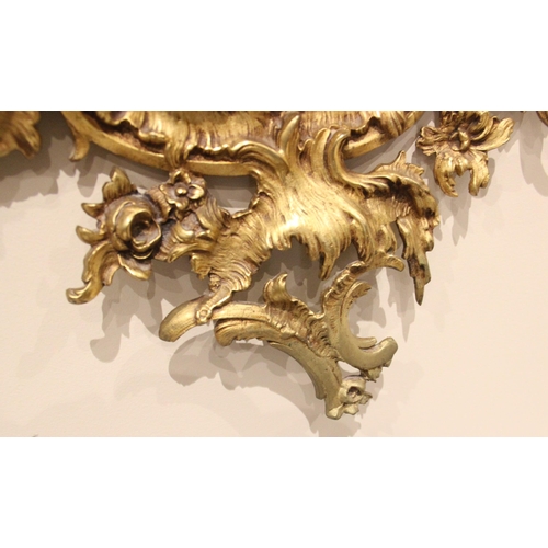 1067 - A Louis XVI style rococo gilt metal wall mirror, 20th century, the shield shaped mirrored plate with... 