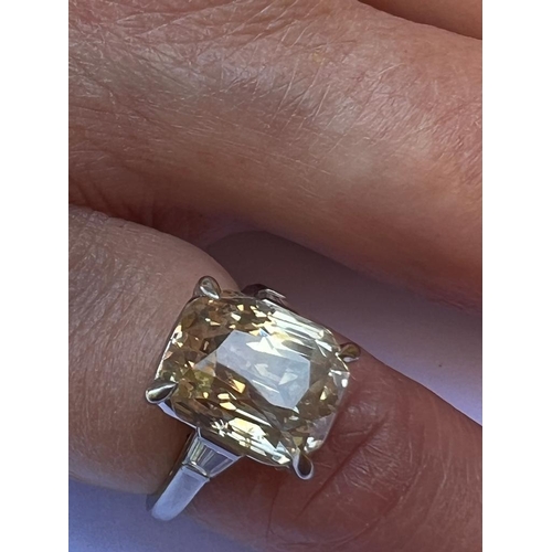 397 - An Art Deco style certified 9 carat yellow sapphire, the central mixed cut sapphire with apricot hue... 