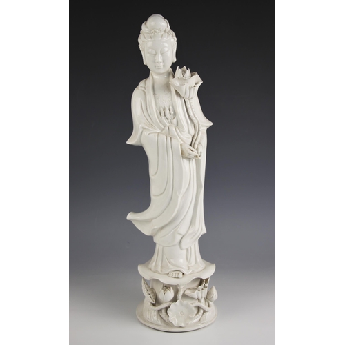 717 - A large Chinese porcelain blanc de chine figure of Guanyin, 19th century, modelled standing in robes... 