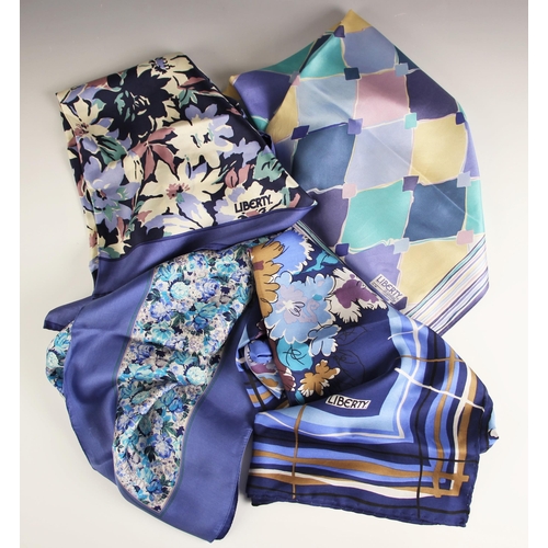 1031 - Four Liberty of London silk scarves, to include; a floral spray scarf in blue, purple and brown tone... 