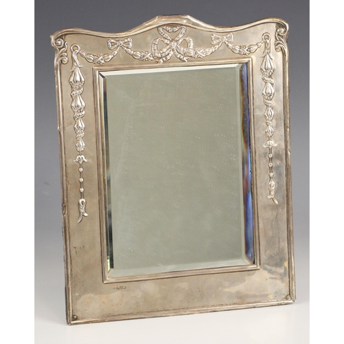 116 - An Edwardian silver mounted mirror, William Neale, Chester 1908, the rectangular frame with embossed... 