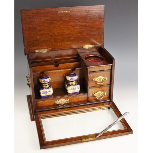 1080 - A late Victorian glazed oak desk top stationery cabinet, the hinged and moulded top over a glazed fa... 