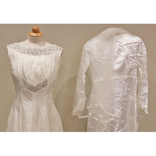 1048 - A 1960's wedding dress, the white satin column dress with high boat neck and long sleeves, embroider... 