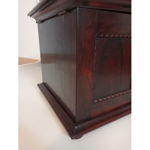 1077 - A William IV rosewood table top work box, the sarcophagus shaped hinged cover applied with moulded b... 