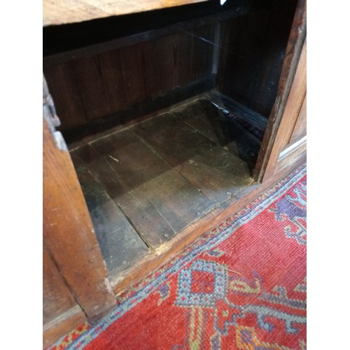 1100 - An early 18th century elm dresser base, the figured and moulded, oversailing top above an arrangemen... 