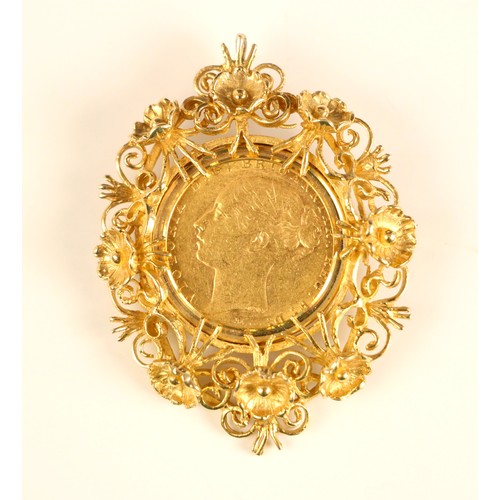 424 - A Victorian full sovereign, dated 1885, within a yellow metal mount/brooch fitting, of scrolling fol... 