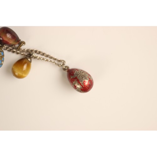 141 - A 20th century Russian miniature egg necklace, the white metal chain suspending fourteen eggs, compr... 