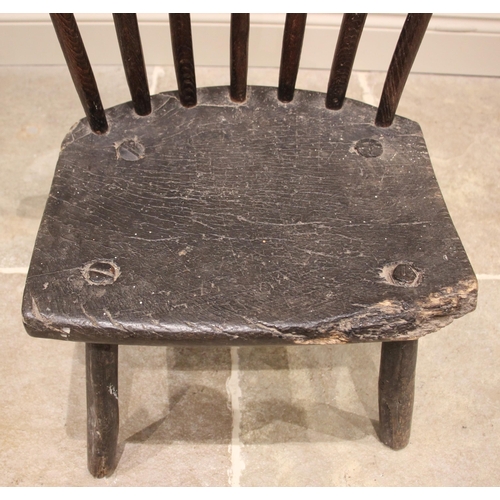 1005 - A small Welsh primitive oak comb back chair, early 19th century, the rough cut crescent shaped top r... 