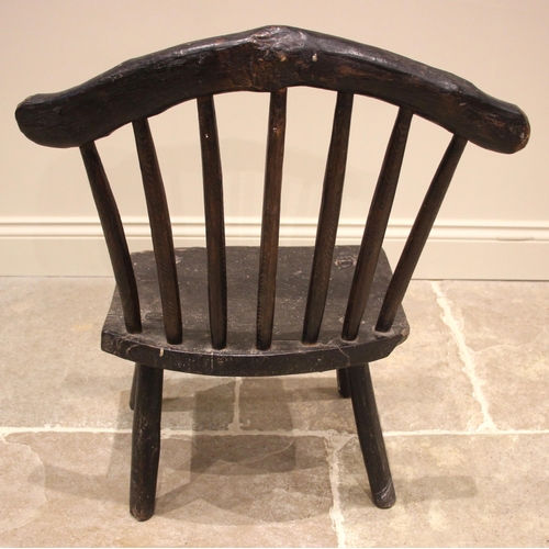 1005 - A small Welsh primitive oak comb back chair, early 19th century, the rough cut crescent shaped top r... 