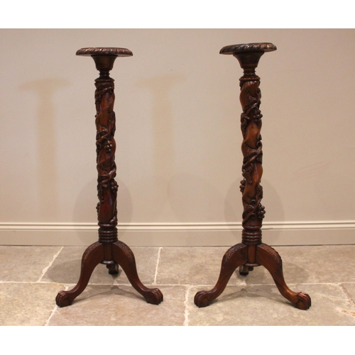 1067 - A pair of 19th century style mahogany torchere, late 20th century, each with a circular tray top ove... 