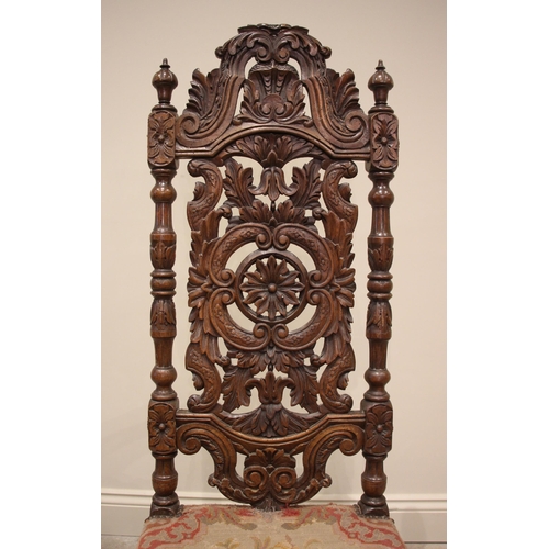 1069 - A carved walnut Carolean style hall chair, 19th century, the carved foliate and 'C' scroll high back... 