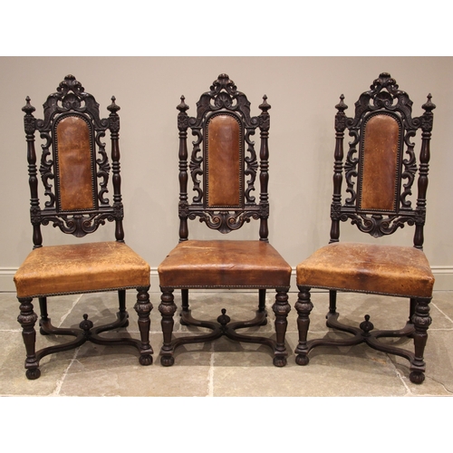 1075 - Three Carolean style oak and tan leather hall chairs, late 19th century, each with an arched padded ... 