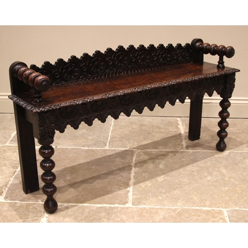 1078 - A Victorian carved oak window/hall seat, the shaped back rest carved with recurring flowerheads, ext... 