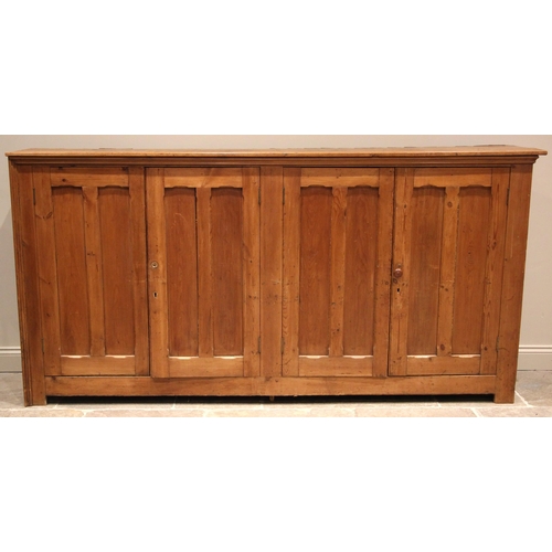 1085 - A large Victorian pitch pine ecclesiastical hall cupboard, formed with two pairs of panelled cupboar... 