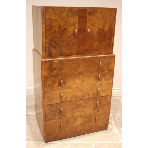 1102 - A 1930's Art Deco figured walnut tall boy, the quarter veneered top over an arrangement of two cupbo... 