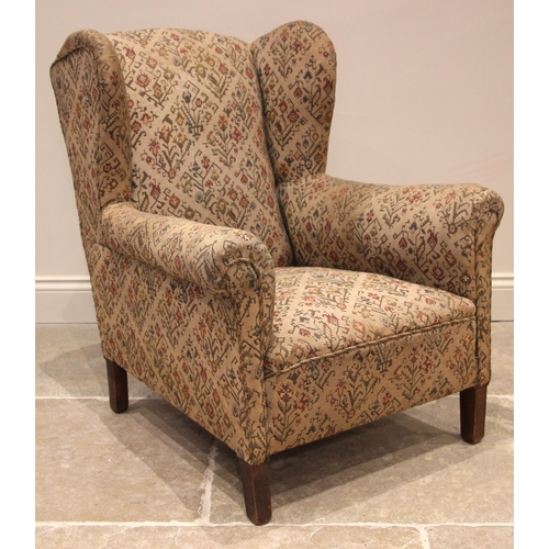 1103 - A ladies wingback armchair, early 20th century, in geometric foliate fabric, the shaped wingbacks ex... 