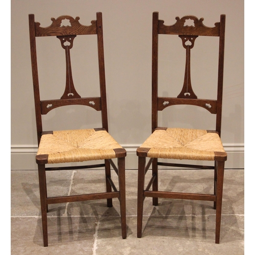 1104 - A pair of Arts & Crafts oak and rush seated bedroom/side chairs, early 20th century, each chair with... 