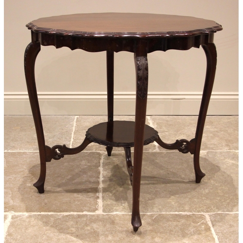 1106 - An Edwardian mahogany occasional table, the shaped top with a moulded edge, upon slender leaf moulde... 