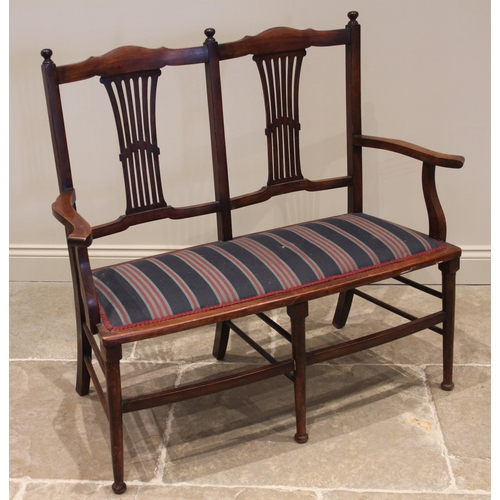 1114 - An Edwardian mahogany upholstered two-seater hall/parlour chair, the twin pierced splats above a pad... 