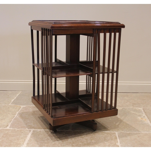 1115 - An Edwardian walnut revolving bookcase, the square moulded top over two tiers, enclosed by lath side... 