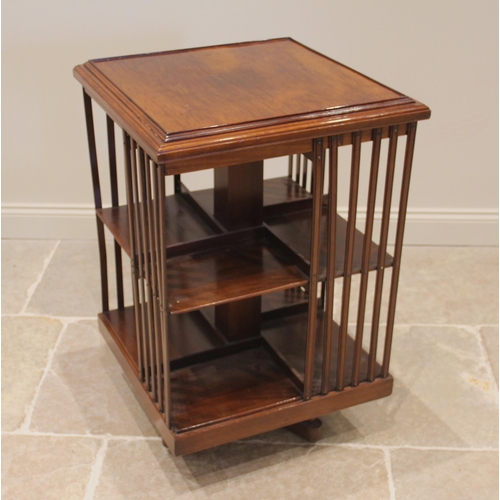 1115 - An Edwardian walnut revolving bookcase, the square moulded top over two tiers, enclosed by lath side... 