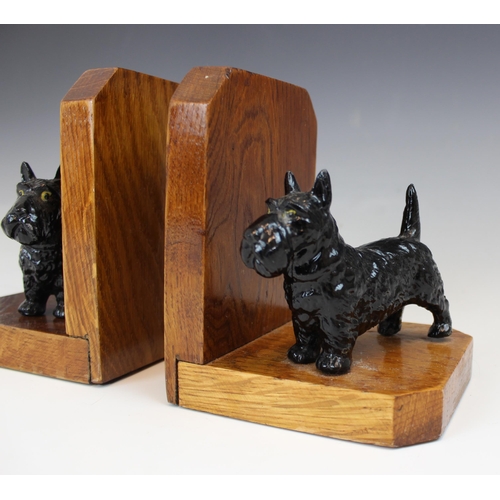 391 - A pair of Art Deco oak bookends, 20th century, each modelled with spelter Scottish Terriers on oak b... 