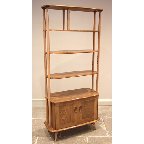 623 - An Ercol honey elm and beech Windsor giraffe open bookcase, mid to late 20th century, formed with fo... 