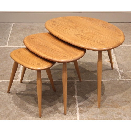 626 - An Ercol nest of three blonde elm and beech pebble tables, late 20th century, the rounded table tops... 