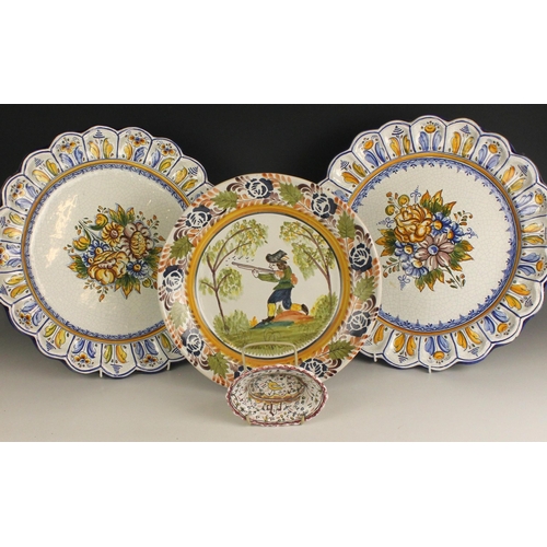 693 - A pair of faience chargers of large proportions, 20th century, each well decorated with a central fl... 