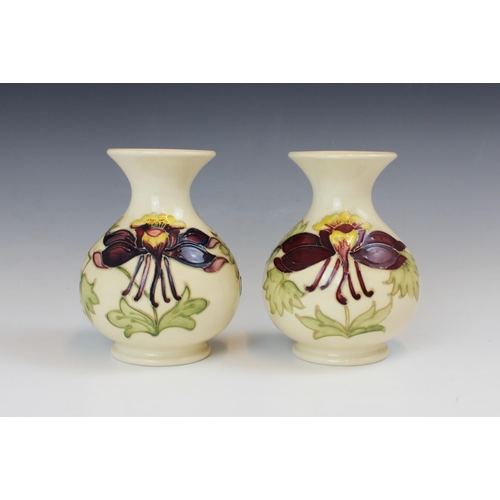 694 - A pair of Moorcroft Columbine pattern vases, 20th century, of globular form with flared neck, impres... 