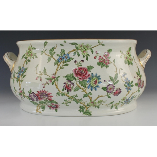 699 - An earthenware footbath, 19th century, of twin handled form, with floral and foliate decoration thro... 