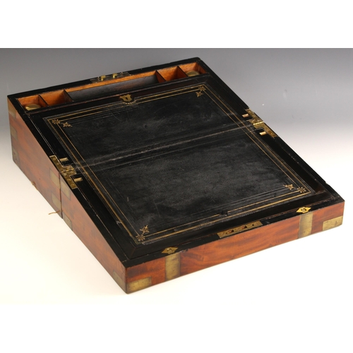 950 - A 19th century mahogany brass bound campaign writing box, the hinged cover centred with a brass cart... 