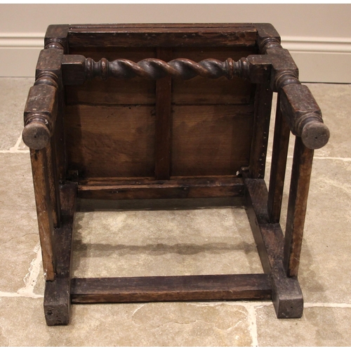 972 - A 17th century oak back stool, probably Lancashire, the three spherical finials over a scrolled cres... 