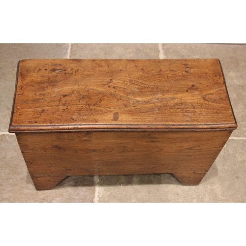 978 - An 18th century elm six plank coffer bach, with a hinged and moulded cover, upon 'V' cut end support... 