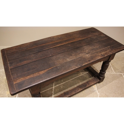 980 - An 18th century oak refectory table, the cleated plank top upon turned vase and block shaped legs, u... 