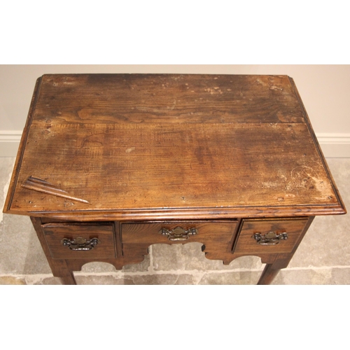 989 - A George II oak and elm low boy, mid 18th century, the rectangular moulded top over an arrangement o... 