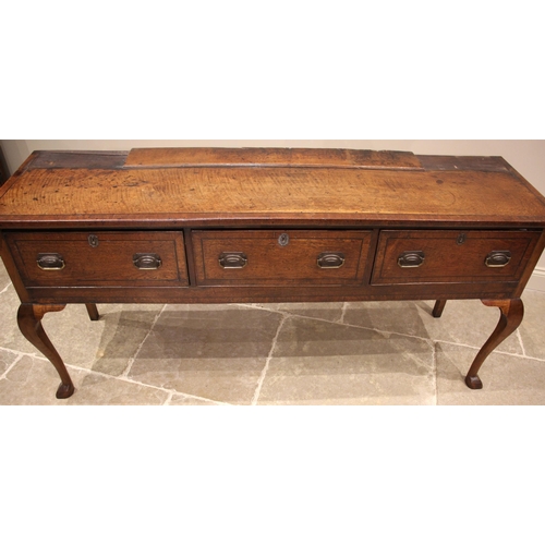 992 - A George III oak dresser, the reduced plate rack with two open shelves flanked by spice cupboards, u... 