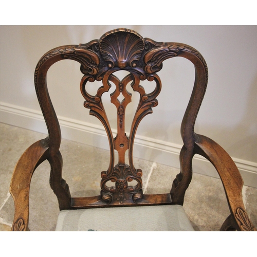 1008 - A George II style walnut elbow chair, late 19th/early 20th century, the carved shell crest uniting a... 