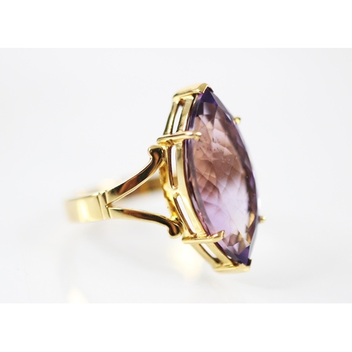 170 - An untested amethyst dress ring, the marquise cut amethyst six claw set in yellow metal, leading to ... 