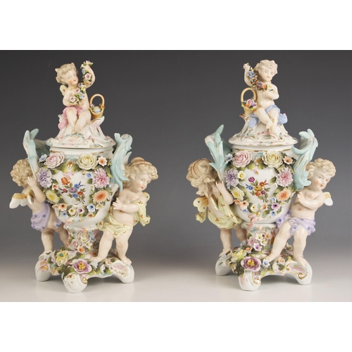 656 - A pair of German porcelain pot pourri and covers, 19th century, each modelled with cherubs supportin... 