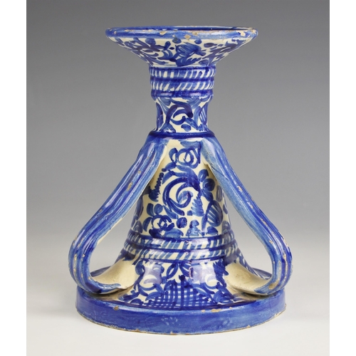 660 - A faience candlestick, 20th century, decorated with a blue foliate design to a white ground, three h... 