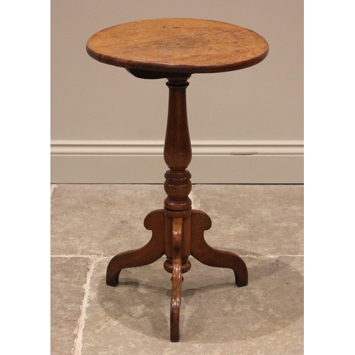 1061 - A Victorian golden oak wine/lamp table, the figured circular top upon a slender baluster pedestal an... 