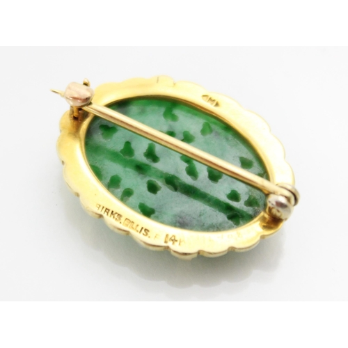 208 - A Birks Ellis ‘jade’ brooch, the carved oval panel with scalloped edge depicting floral detail, with... 