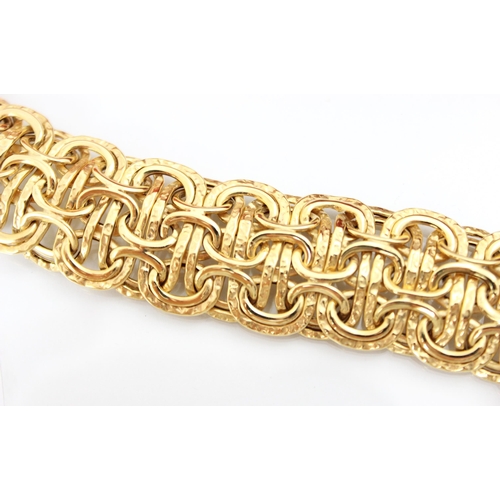 211 - A yellow metal fancy link bracelet, the interlocking oval links with planished and plain polished de... 